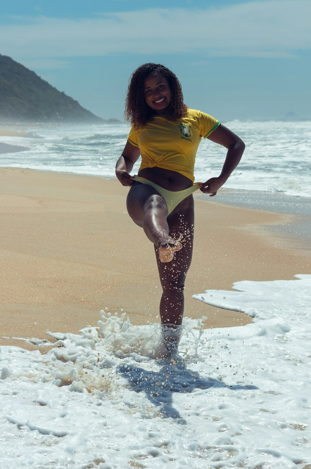 Studio portrait of a brazilian woman with curly hair smiling